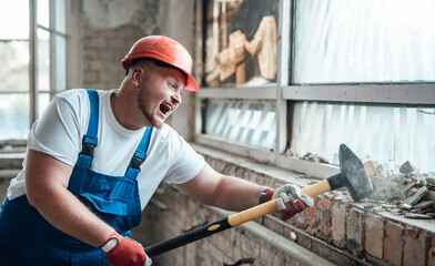 Construction worker destroys a wall with his huge sledgehammer