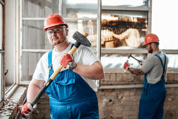 A couple of conscientious builders work hard to remove plaster from old walls