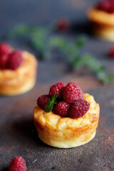 Delicious curd muffin with raspberries on a dark background.