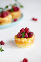Delicious curd muffin with raspberries on a light background.