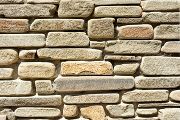 Background of old brick stone wall in sunny summer day. Mediterranean style background 