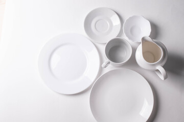 Obraz na płótnie Canvas a group of different white ceramic plates on white background