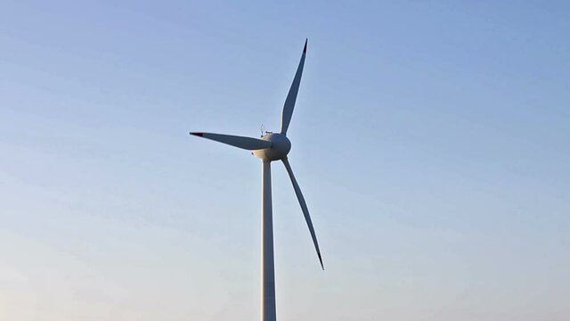 Holic turbines rotating in the wind, blue sky, without nuances, medium shot