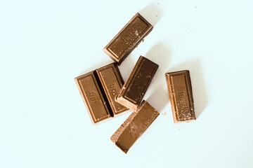 Milk chocolate pieces on a white background