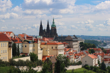 Obraz premium Prague's St. Vitus Cathedral in Hradcany against the background of clouds on a hot, Sunny summer day.