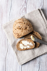 whole grain rye bread cut into slices with butter on a wooden table