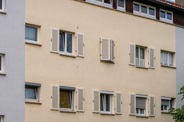 Fototapeta na wymiar barren facade of an apartment building with wooden shutters