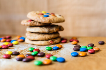 Chocolate chip cookie with candy colors on a brown background