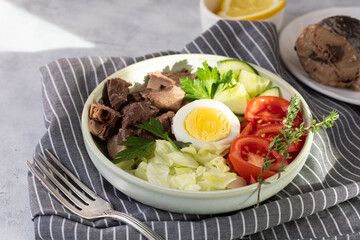 Salad with canned tuna, egg and vegetables - tomatoes, cucumber and lettuce.