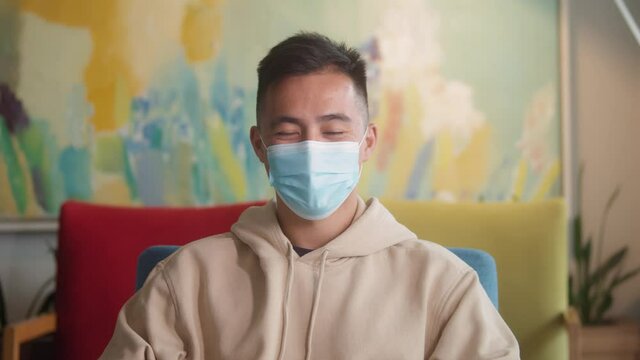 Portrait of korean asian man in protection medical mask, post covid lockdown epidemic coronavirus. happy designer freelancer man wearing mask