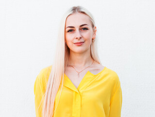 Pretty smiling joyfully female with fair hair, dressed casually, looking with satisfaction at...