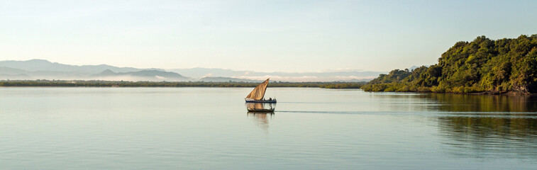 Nosy Be, Madagascar: traditional sailing boat and canoe sail out on the Indian Ocean from Port Ankify, Ambanja district, Northern Madagascar. 