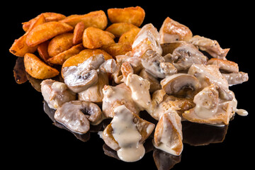 Delicious Chicken pieces with melted cheese and fried potatoes  with reflection, isolated on black background