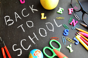 School supplies on blackboard background ready for your design top view copy space. back to school