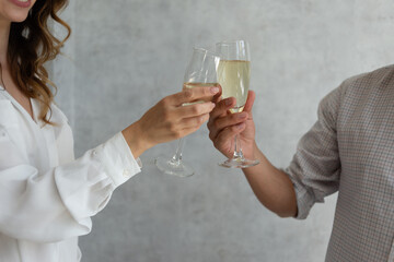 Close up of two glasses of champagne in male and female hands. Christmas concept, saint valentine.