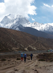 Fototapeta premium Trekkers at Everest trail with snow mountain in background, Himalaya, Nepal