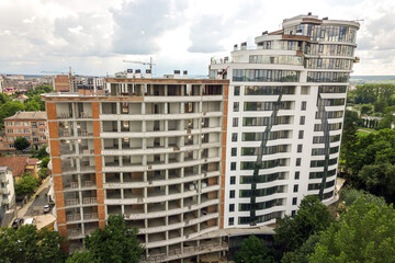 Aerial view of tall residential apartment building under construction. Real estate development.