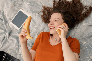 Close up lifestyle portrait of young smiling girl lying on the lawn. Pretty curly woman make a joke...