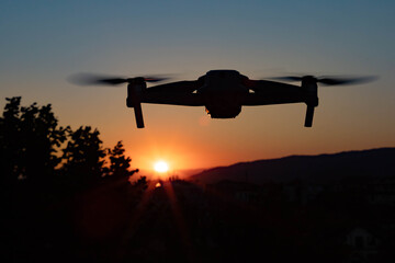 Photo of a drone flying in the air in the sunset light