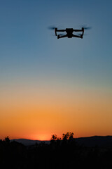 Fototapeta na wymiar Photo of a drone flying in the air in the sunset light