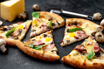 Pizza carbonara with bacon, cheese, mushrooms, quail eggs, creamy sauce on a stone background