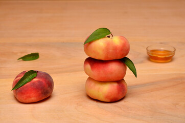 ripe flat peaches on a wooden table