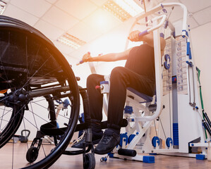 Disabled man doing strength exercises separate from the wheelchair.