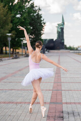 Fototapeta na wymiar Young and beautiful ballerina posing on the street