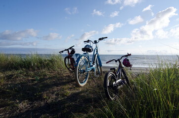 Fototapeta na wymiar Bicycles and helmets parked over sand beach in Westport