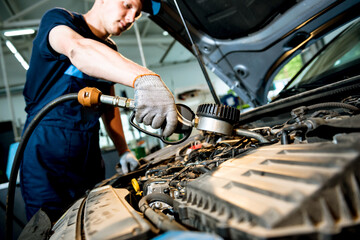 Car mechanic change engine oil. Car repair. Service station