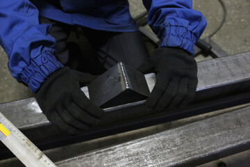 Locksmith holds an iron corner after grinding