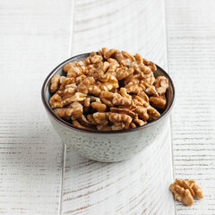 Walnut in a bowl on a light wooden table. Healthy snacks, healthy food. Nuts. Copy space.