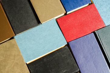 Books next to each other top view. Background from multicolored old books.