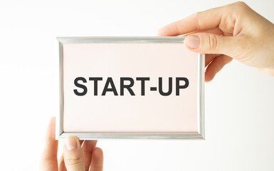 businessman hand showing poster of start up icon as concept
