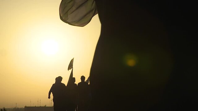 KARBALA, IRAQ - NOV 2017: Silhouette of crowd of pilgrims walking in Arbaeen pilgrimage at sunrise. Every year, millions of Shiite muslims come from all over the world to Karbala to walk Arbaeen