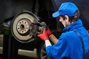 Automobile brake pads replacement in car repair shop or garage - obrazy, fototapety, plakaty