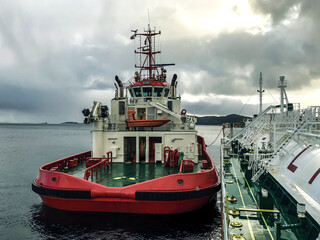 the tug is moored near the gas tanker