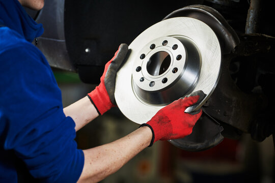 Automobile brake disk replacement in car repair shop or garage