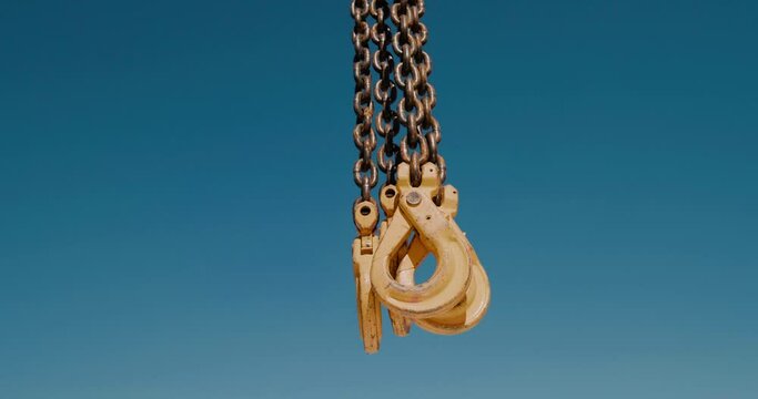 Close-up of mobile crane hooks. Hooks on chains against blue sky