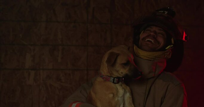 Dog licking firefighter after being saved from fire - laughing and smiling