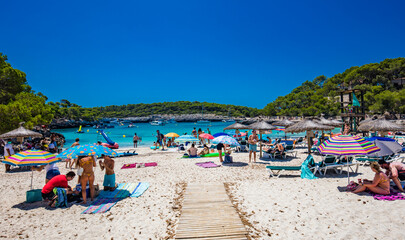 Fototapeta na wymiar CALA MONDRAGO, Majorka, Spain, 24 July 2020 - People enjoy the beach in summer, Parque Natural de Mondrago. Santanyi. Malorca. Spain