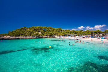 Fototapeta na wymiar CALA MONDRAGO, Majorka, Spain, 24 July 2020 - People enjoy the beach in summer, Parque Natural de Mondrago. Santanyi. Malorca. Spain