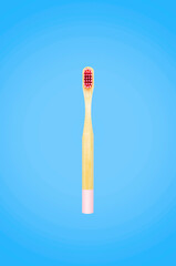 Pink bamboo toothbrush on blue background isolated, sample of toothbrush  top view, flat lay style