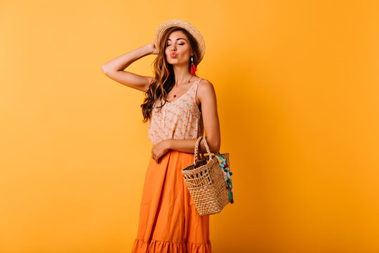 Jocund woman in summer skirt posing with kissing face expression. Indoor photo of relaxed elegant ginger lady enjoying leisure time in studio.