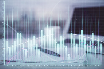 Double exposure of financial graph drawings and desk with open notebook background. Concept of forex market