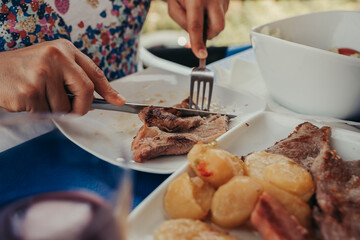 Adult woman cutting meat in a restaurant