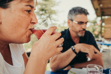 Adult couple drinking red summer wine in a restaurant.