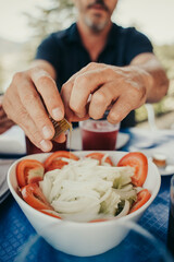 Man seasoning a salad.