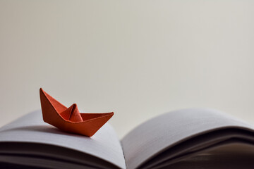 Paper, red boat, origami on open, blank pages of the diary on a light background. Place for your...