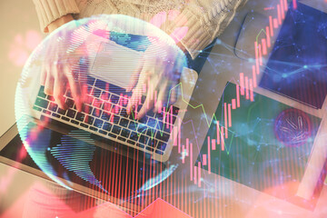 Double exposure of woman hands working on computer and financial theme hologram drawing. Top View. Business concept.